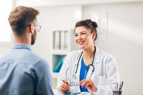 Woman Doctor talking to Patient at her Medical Office