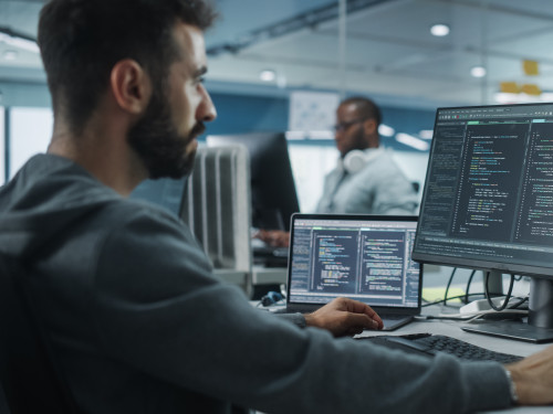 Diverse Office: Enthusiastic White IT Programmer Working on Desk