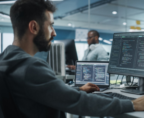 Diverse Office: Enthusiastic White IT Programmer Working on Desk