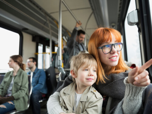 Mother and son pointing looking out bus window