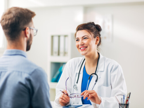 Woman Doctor talking to Patient at her Medical Office