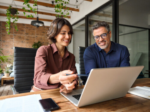 Business team two executives working together using laptop computer in office.